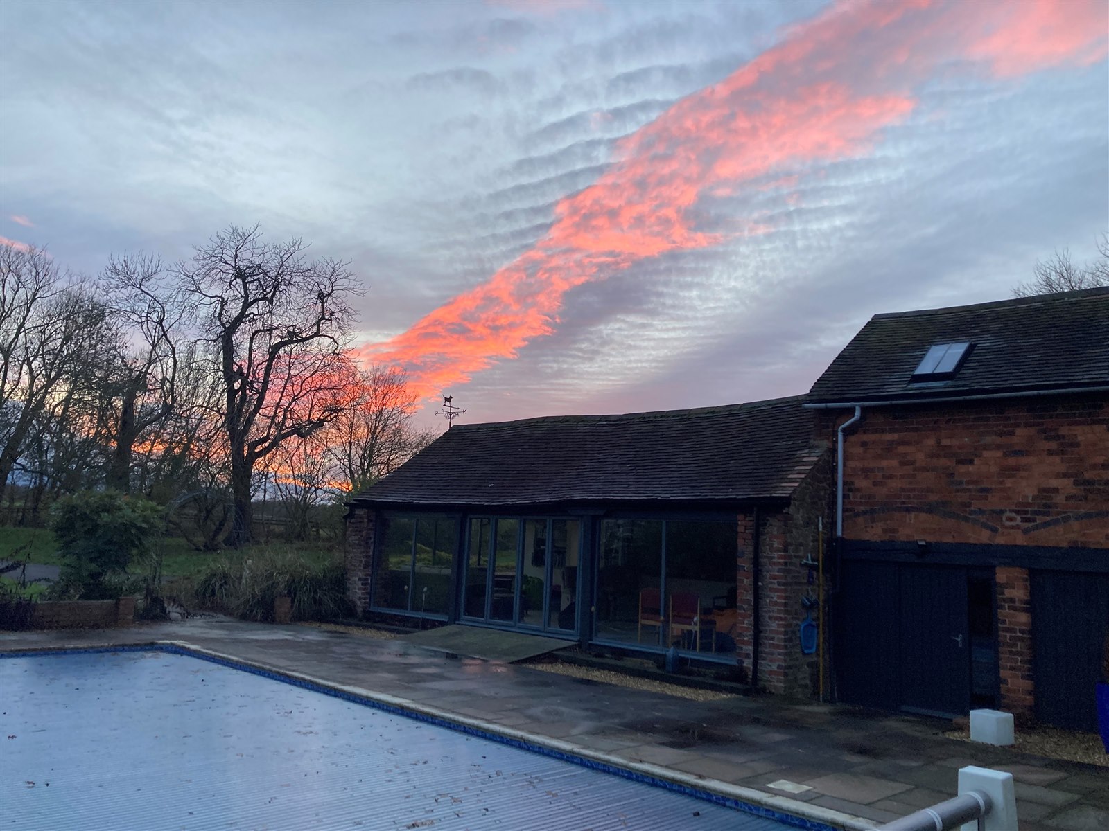 The first red band of the sunset, seen from beside the swimming pool at Reaside Farm